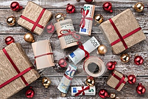 Old wooden background, American money, gifts and Christmas items. Top view. Different values