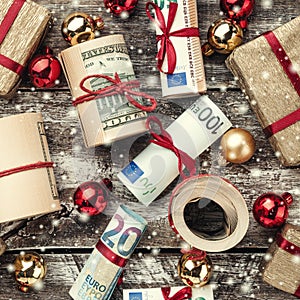 Old wooden background, American money, gifts and Christmas items. Top view. Different values. Effect snowflakes