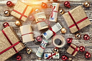 Old wooden background, American money, gifts and Christmas items. Top view. Different values. Light effect