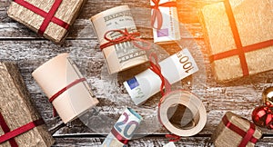Old wooden background, American money, gifts. Top view. Different values. Space for text. Light effect