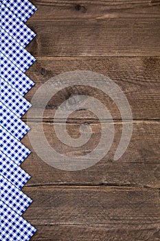 Old wooden background with blue and white checked border for bav