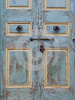 Old wooden background with old iron latch and various padlocks. Close up of worn wooden door with iron enclosures. Construction