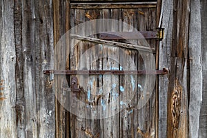 old wooden barn door with iron padlocks and rustes steel reinforcement bands