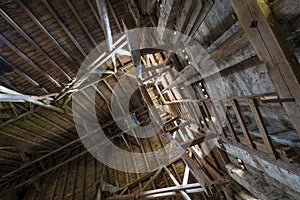 Old wooden barn roof with light shining through wooden boards