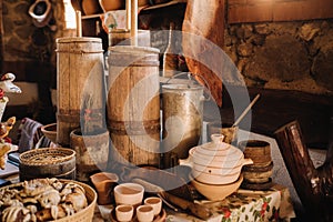 Old wooden barrels and dishes on the table in the village. Rustic antique tableware