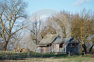 An old wooden bath house on the outskirts of the village. Against the background of the cloudy sky. Concept: old buildings,