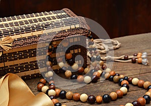 Old wooden beads, wooden casket and hairbrush on table