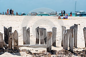 Old wooden beams from former pier on a beautiful caribbean beach on Isla Muheres, Mexico