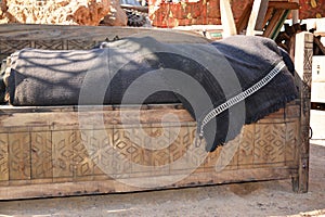 old wooden bed with a blue woven bedspread