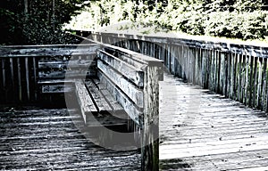 Old Wooden bench on a bridge near a road in summer. Grey image