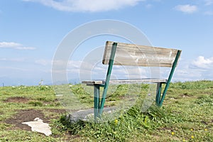 Old wooden bench on peak of summer green mountains,