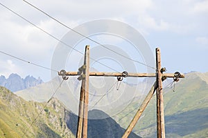 Old wooden big energy power mast and mountain landscape