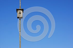 Old wooden bird house and blue sky background