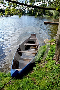 Old wooden blue boat near resort lake coast