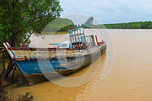 Old Wooden Boat, Abandoned and Deteriorating on a Muddy River