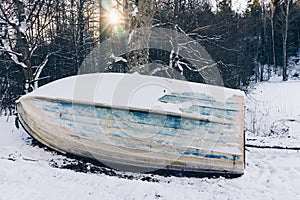 Old wooden boat ashore in winter