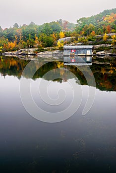 Old Wooden Boat House on a Calm Lake in the Fall