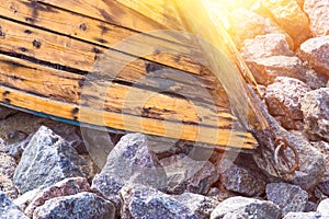 Old wooden boat lying on stones closeup