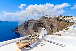 Old wooden boat on roof of a house in beautiful Firostefani village with typical white architecture, Santorini island, Greece