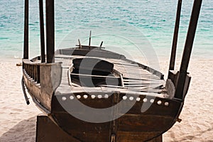 Old wooden boat on a sea sandy beach against the sea