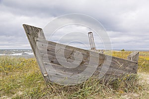 Old wooden boat with ship Memorial in the background