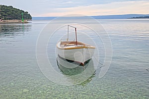 An old wooden boat on the turquoise surface of the Adriatic Sea, island Korcula, Croatia