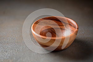 Old wooden bowl on a grey table