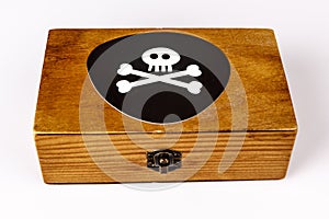 Old wooden box with pirate symbol - skull and bones on black