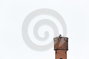 An old wooden and brick water firestation orange rural tower. Isolated on a clear white sky background