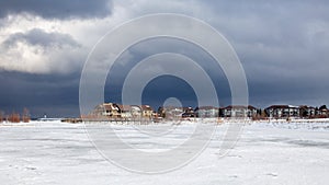 An old, wooden bridge crosses a section of frozen Georgian Bay waterfront in Collingwood