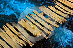 Old wooden bridge and a flow river