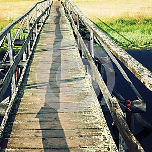 An old wooden bridge. Sunny day. Empty walkway.