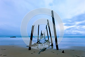 Old wooden bridge to the sea in bad weather day.