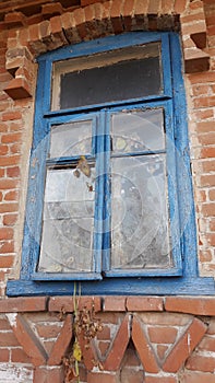 Smashed glass Window with old wooden frame on grunge wall damaged house