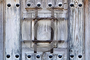 Old wooden brown door with wrought iron details