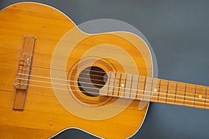 Old wooden brown guitar on a dark background