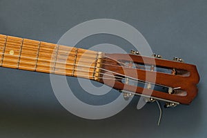 Old wooden brown guitar on a dark background