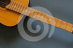 Old wooden brown guitar on a dark background