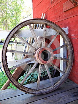 A old Wooden Carriage Wagon Wheel Next to a Barn on a Farm