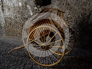 Old wooden cart for agricultural work, well preserved, resting on a stone floor