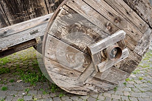 Old wooden cart with a stone masonry wall on the background with a cartiera sign paper mill in Italian language.