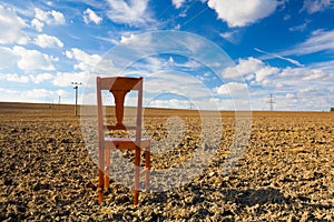 Old wooden chair on the empty field