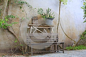 Old wooden chair in the garden against old cement wall background