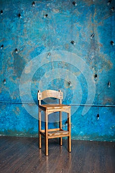 Old wooden chair in grunge room with blue wall