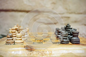 Old wooden chess pieces on a tree trunk board