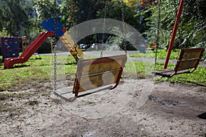 Old wooden children swing on iron chains