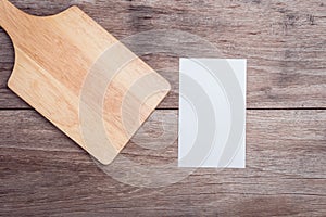 Old wooden chopping board and blank paper on wooden table top vi