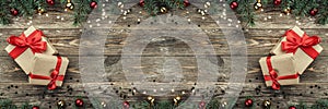 Old wooden Christmas background. Fir branches with baubles and gold stars. Xmas horizontally card, gifts. Top view