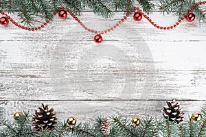 Old wooden Christmas background. Fir branches and cones. Gold and red baubles and garlands