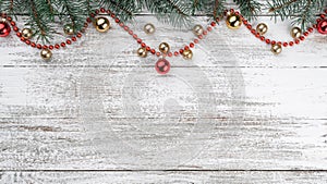 Old wooden Christmas background. Fir branches. Gold and red baubles. Red garlands. Top view. Space for your text. Xmas card.